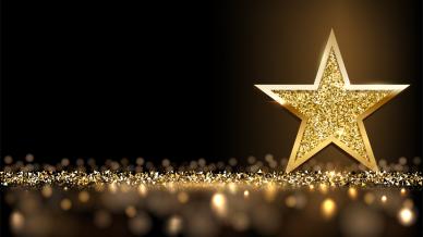 A golden star with gold glitter on a black background 